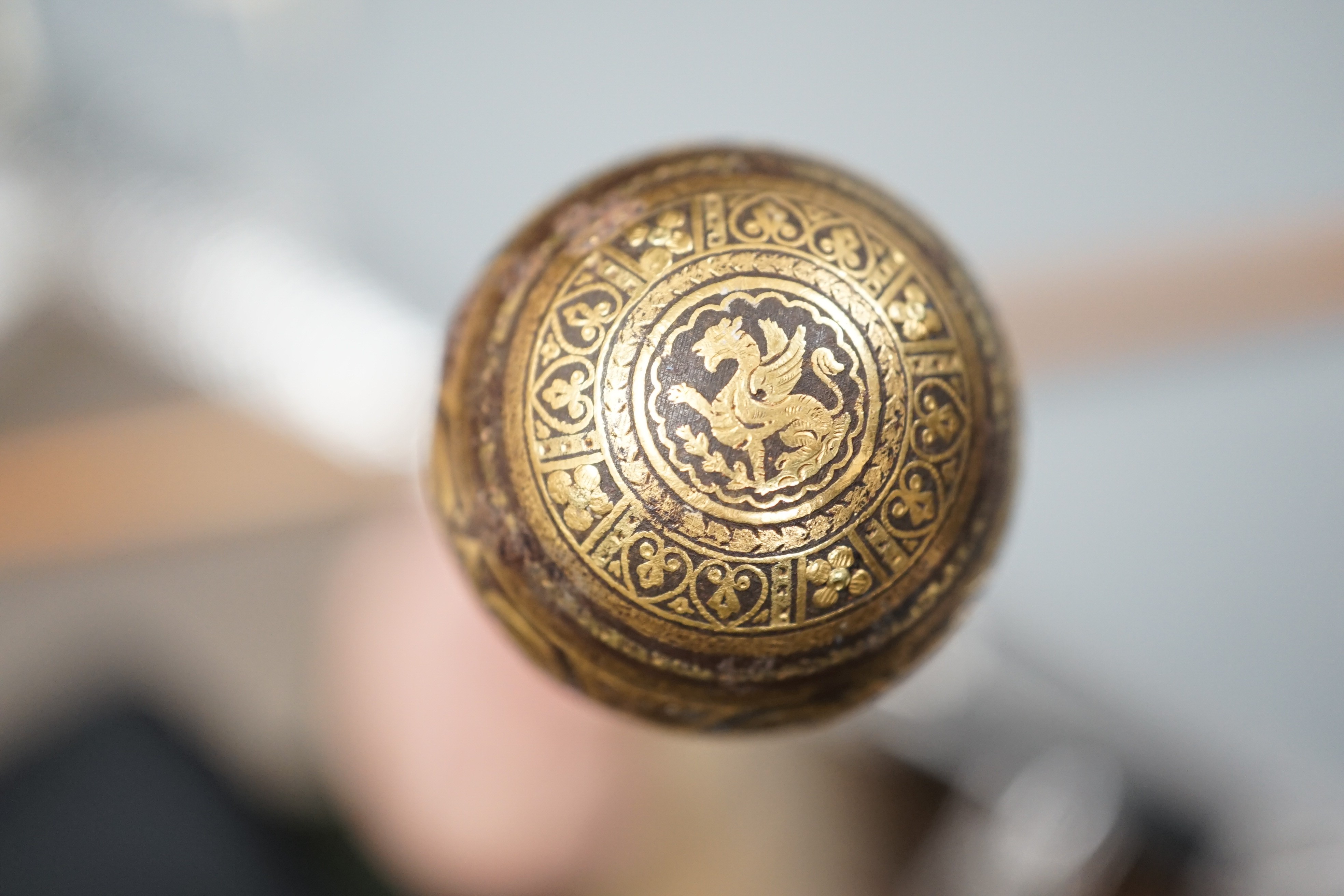 An early 20th century ivory ‘sphinx’ parasol handle, 84cm, together with another gold and iron damascened parasol handle, 62cm